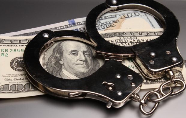 image of handcuffs on top of cash