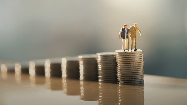 older couple standing on stack of coins