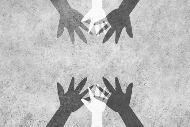 Hands reaching in to unite against racism.