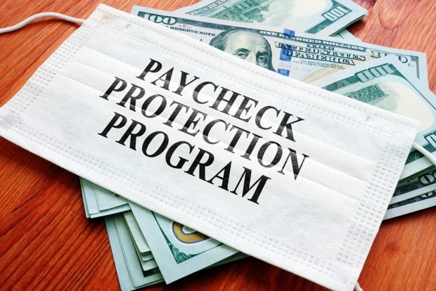 Paycheck Protection Program with cash and a mask