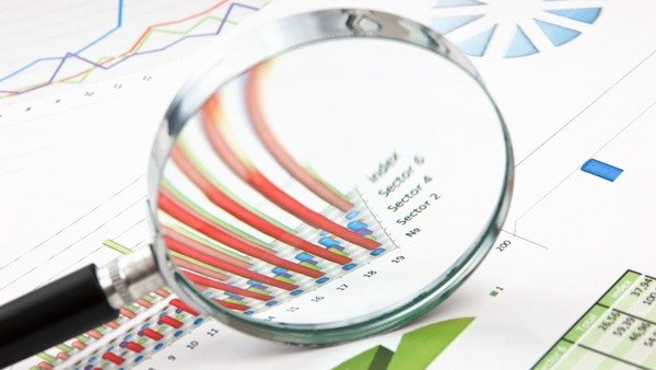magnifying glass over sheet of financials