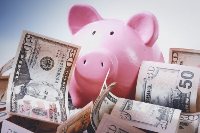 pink piggy bank with $50 bills floating around it