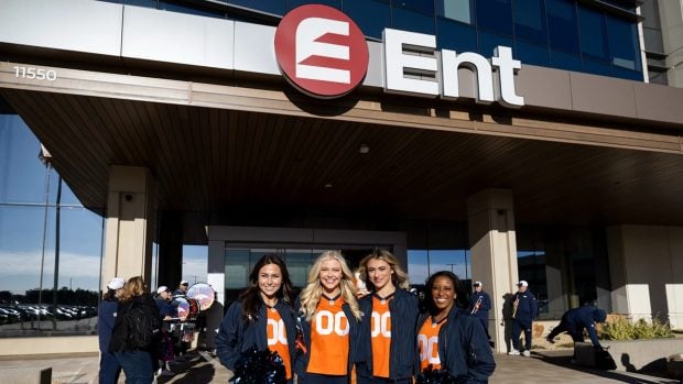 Some Denver Broncos cheerleaders stand in front of Ent Credit Union on May 6, 2024. Credit/Ent