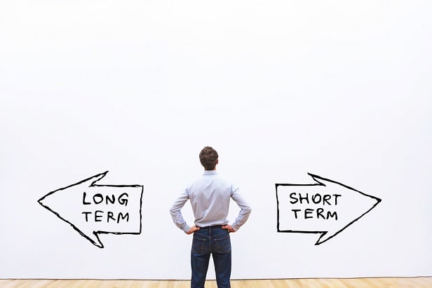 man looking at arrows saying long term and short term