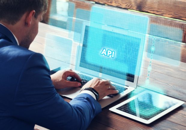 man on laptop with API written on screen