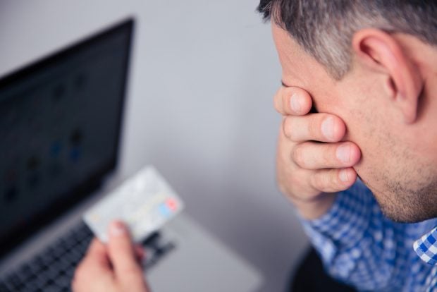 man on laptop discovering credit card fraud