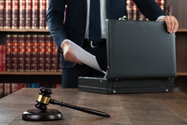 attorney places files in a briefcase inside a judge's chambers.