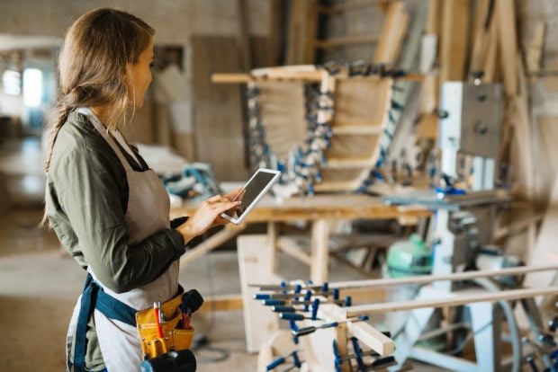 small business owner with tool belt and tablet