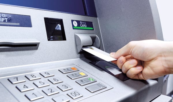 Debit card being inserted into an ATM