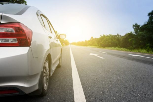 New car driving down road