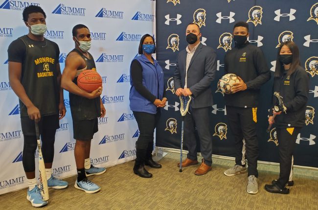 Twanda Christensen, vice president of marketing and community engagement for The Summit FCU (center left,) and Aaron Bouyea, MCC's director of athletics (center right), pose with MCC student athletes.