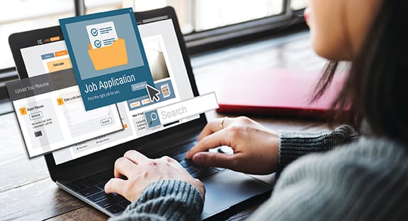person fills out job application on laptop
