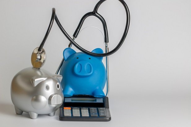 Piggy banks with calculator and stethoscope
