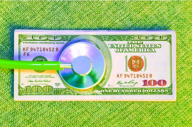 stethoscope lying on U.S. currency
