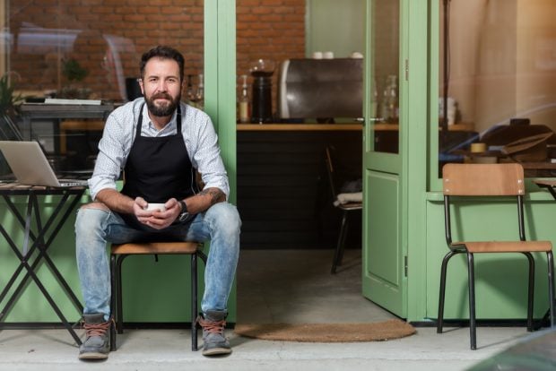 Man in apron outside store