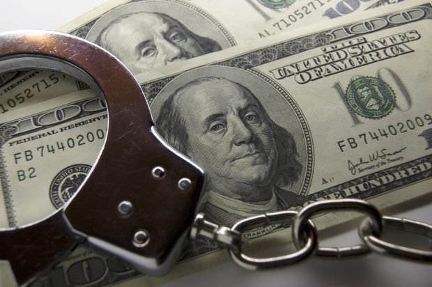 pile of cash with handcuffs on top
