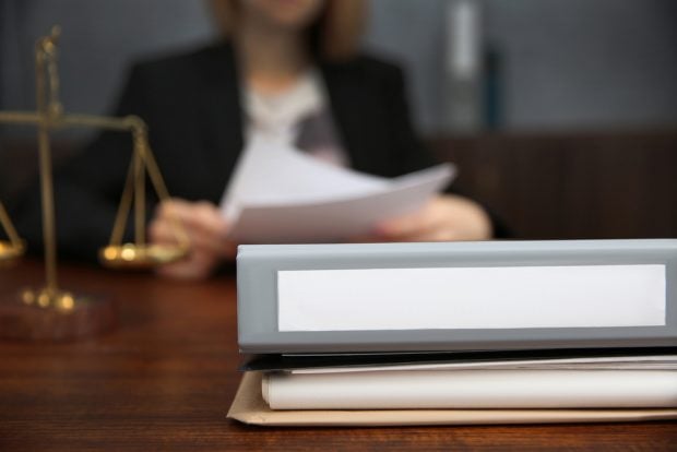 woman reviews lawsuit at desk
