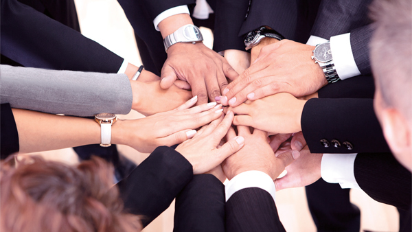 multiple hands of business people together