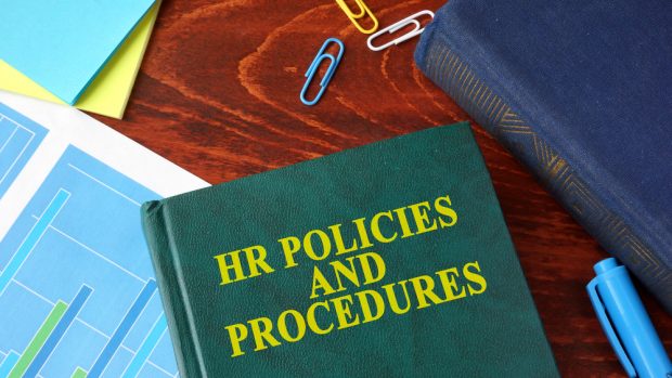 HR Policies and Procedures book sitting on a desk