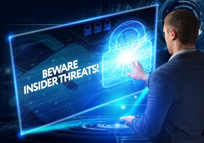businessman touching screen with lock and the text "beware insider threats"