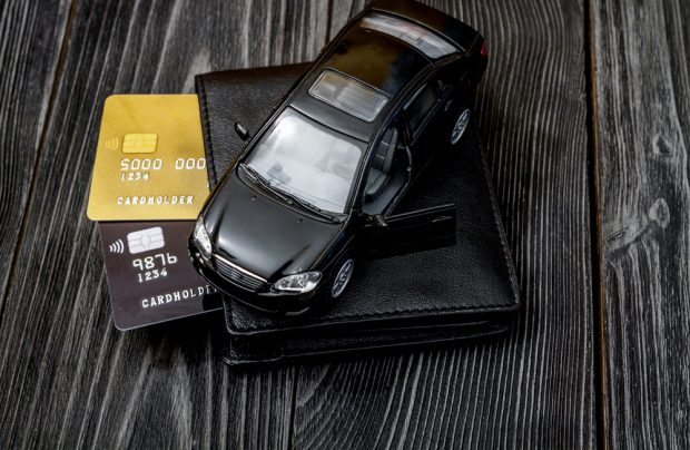 mini car of wallet with credit cards sticking out