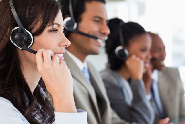 Smiling row of employees with headsets