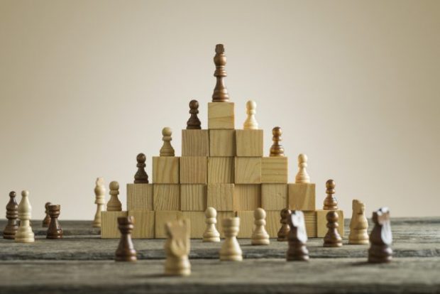 Chess pieces stacked on a pyramid of blo