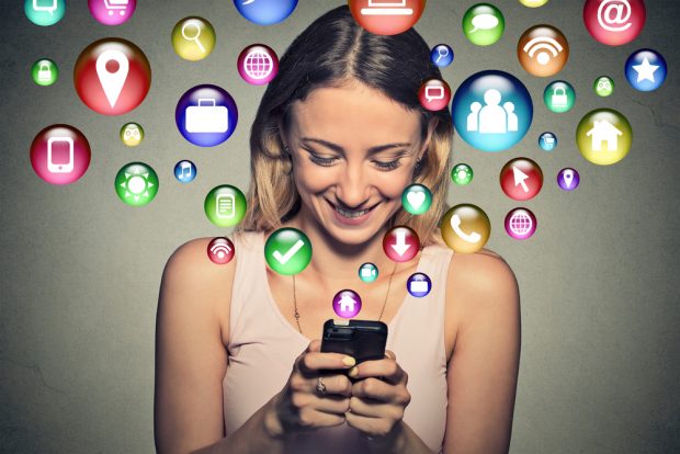 smiling woman on cell phone surrounded by social icons