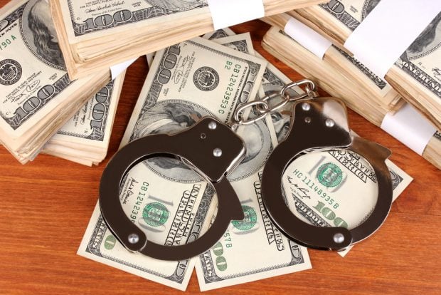 Piles of cash with handcuffs on top