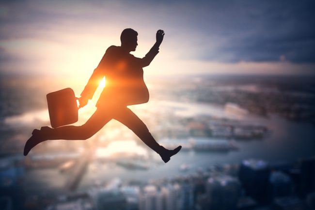 businessman leaping over city