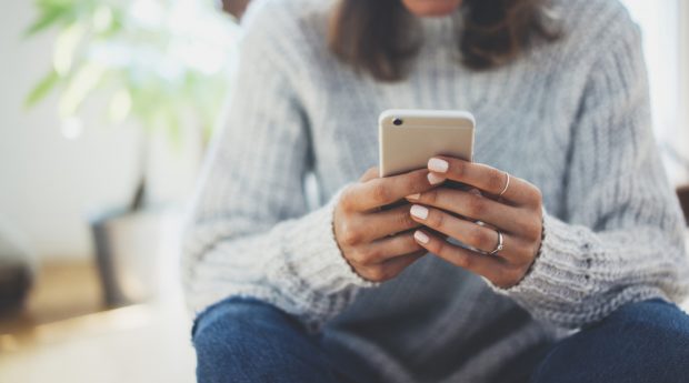 woman reading text on smartphone