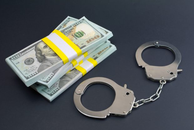 handcuffs next to a pile of cash