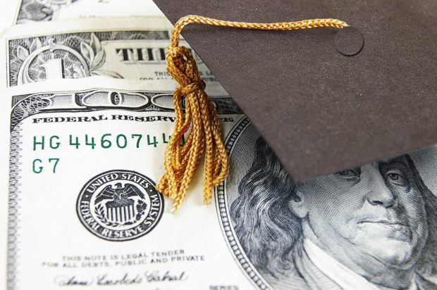 graduation cap on top of $100 bills.