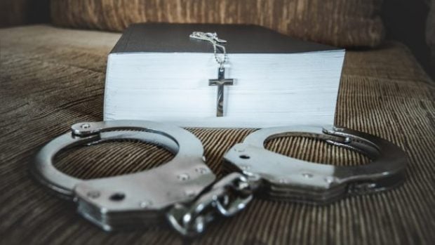 Bible, cross, church and handcuffs