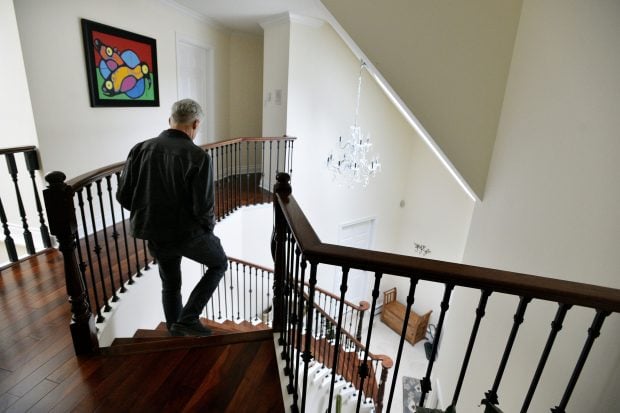 man walking down stairs of his home