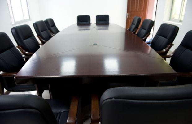 Empty board room with chairs around a large table.