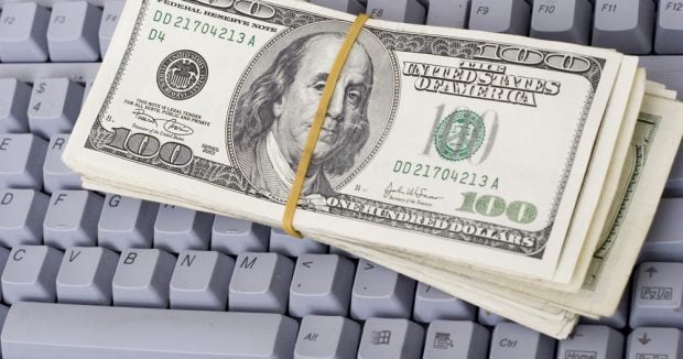 stack of cash on a computer keyboard
