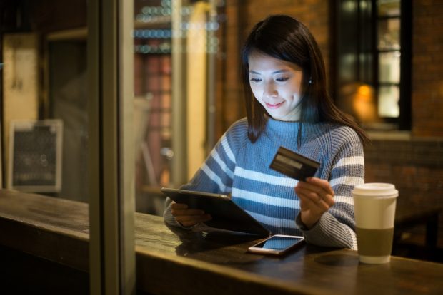 woman using credit card to make a mobile purchase