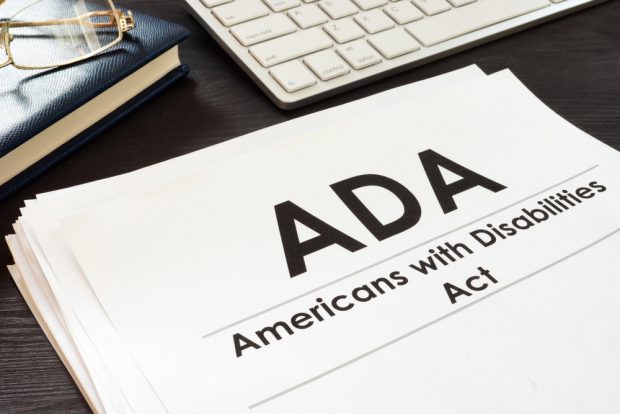 Copy of the Americans with Disabilities Act sitting next to a computer keyboard.