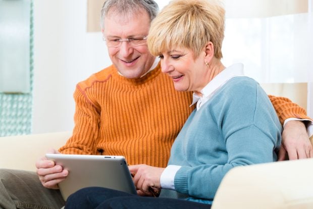 couple sitting on the couch looking at their finances