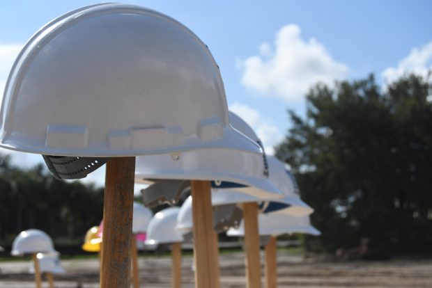 hard hats sitting on shovels