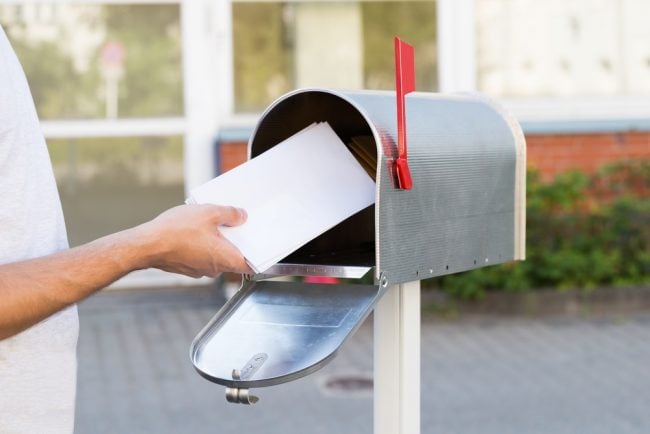 Person removing envelopes from mailbox