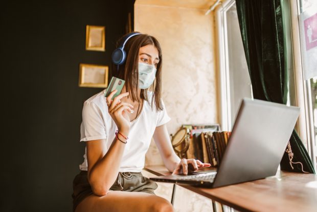 woman wearing a mask using a credit card