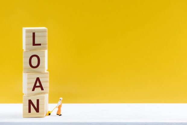 person pulling blocks that spell 'Loan'