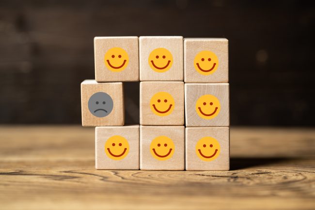 stack of blocks with happy faces and one with sad face