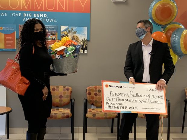 Suncoast CU President/CEO Kevin Johnson presents Ferzeda Richardson with a $1,000 check Dec. 29 for being its 1 millionth member. (Photo courtesy Suncoast CU).