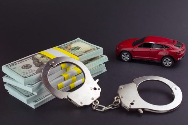 Red car money handcuffs. shopping for vehicles fraud car sale, breaking the law auto dealer concept.
