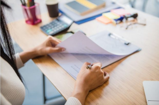 Woman signing title insurance documents.