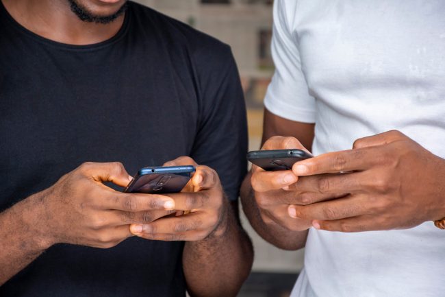 two black people people using their mobile phones