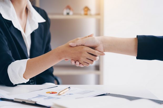 Businesswoman shaking hand for a complete business deal together in meeting room.Teamwork,Partnership and Dealership concept.
